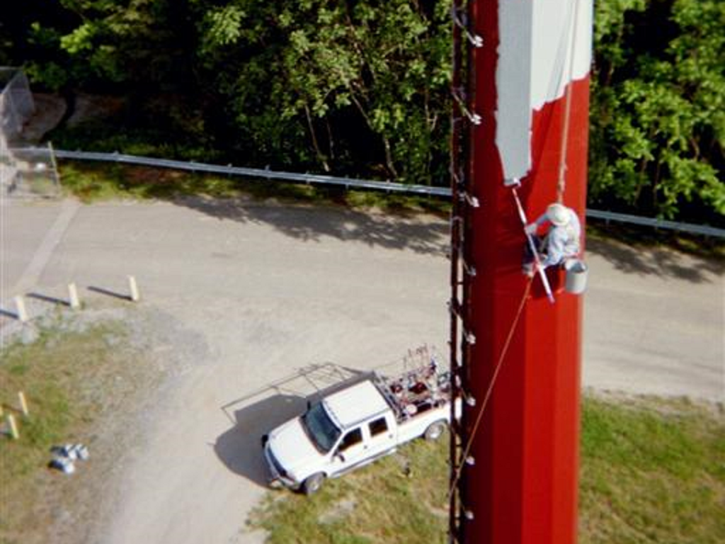 man painting electrical pole