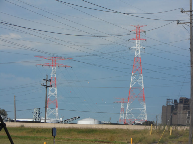 a group of three newly painted transmission towers