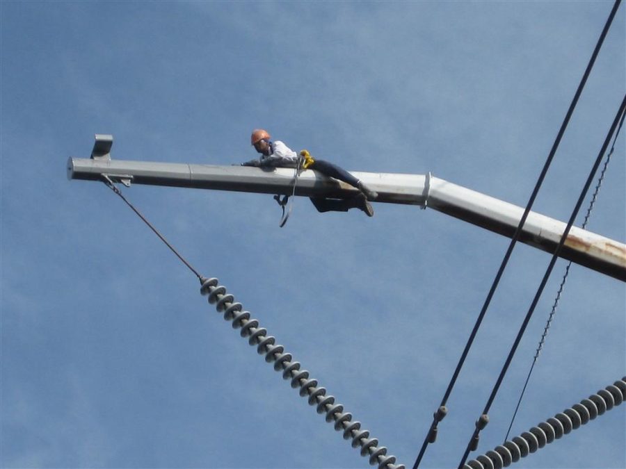 a man painting an electric transmission tower