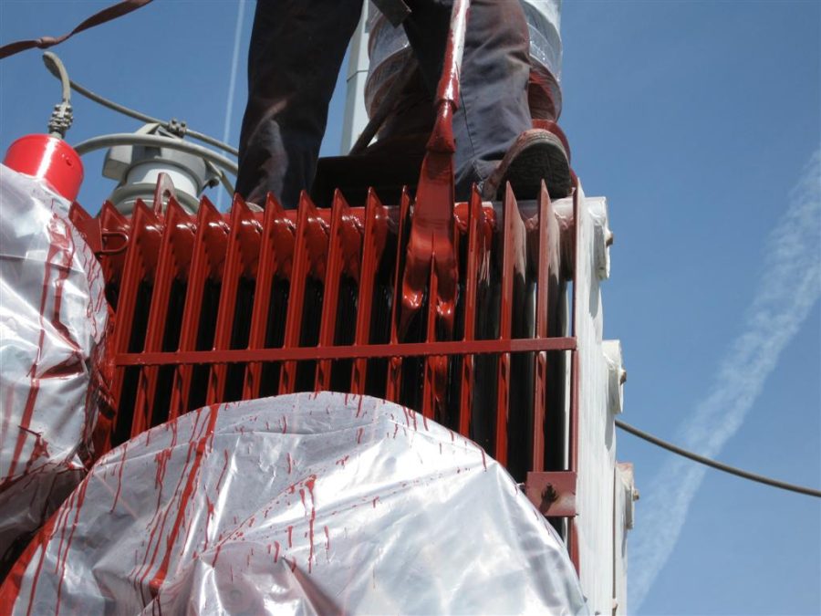 an electrical transformer being painted by a process called flow coating